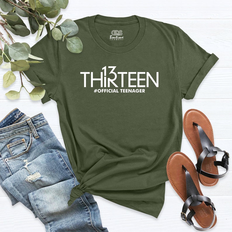 May include: Green t-shirt with white text that says "13 THIRTEEN #OFFICIAL TEENAGER".