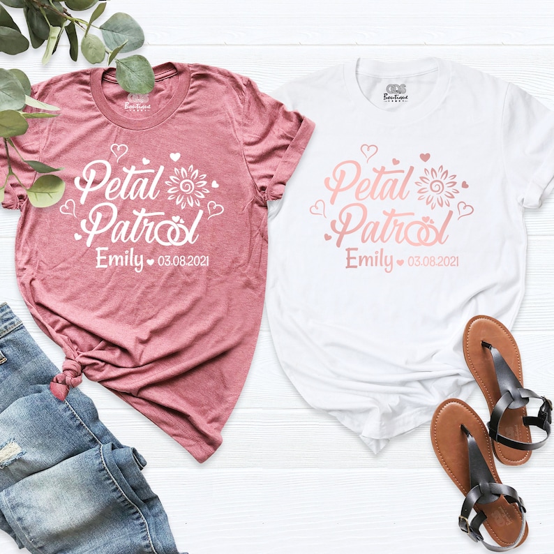 Puede incluir: Dos camisetas blancas con un dise&ntilde;o rosa que dice "Petal Patrol" con un girasol y corazones. El texto tambi&eacute;n incluye el nombre "Emily" y la fecha "03.08.2021".