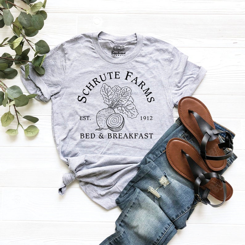 May include: A gray t-shirt with a black graphic of a beet and the text "Schrute Farms Est. 1912 Bed & Breakfast".
