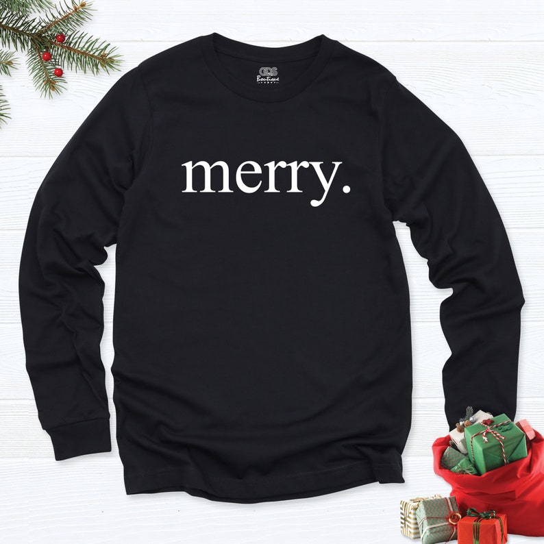 May include: Black long-sleeve t-shirt with the word "merry" printed in white on the front.