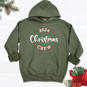 May include: A green hooded sweatshirt with a white circle graphic that says "2024 Christmas Crew".