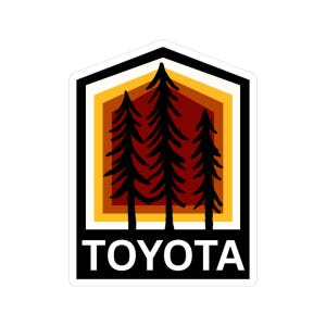 May include: A sticker featuring a stylized design with three black pine trees set against a gradient of orange, yellow, and red hues. The word "TOYOTA" is printed in white at the bottom, within a black border.