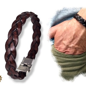 Puede incluir: Un brazalete trenzado de cuero marrón con cierre plateado.