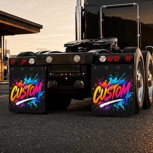 May include: A pair of black mud flaps attached to the rear of a semi-truck. Each mud flap features a vibrant, multi-colored paint splatter design in shades of blue, pink, orange, and yellow, with the word CUSTOM printed in a bold, stylized font.