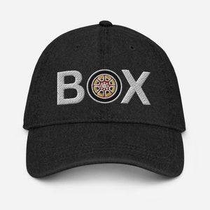 May include: Black denim baseball cap with white embroidered text "BOX" and a red, yellow, and white tire graphic.