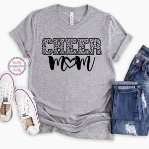 May include: Gray t-shirt with a black and white leopard print design that says "Cheer Mom" with a heart in the middle of the "M".