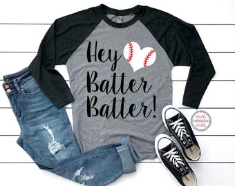 May include: A gray and black baseball themed raglan t-shirt with the text "Hey Batter Batter!" and a red and white baseball heart graphic.
