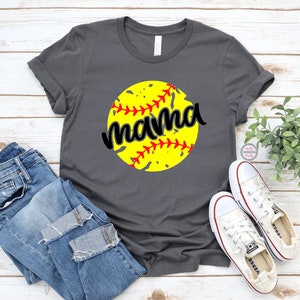 May include: Gray t-shirt with a yellow softball graphic and the word "mama" in black text.