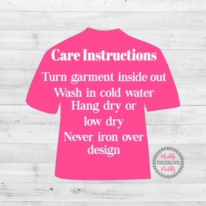 May include: Pink t-shirt with white text outlining care instructions for the garment. The text reads: "Care Instructions Turn garment inside out Wash in cold water Hang dry or low dry Never iron over design".