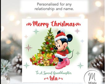 May include: A square Christmas greeting card featuring a cartoon mouse wearing a Santa hat, red coat, and pink boots standing next to a decorated Christmas tree with gifts. The text reads Merry Christmas, To A Special Granddaughter, and Isla.