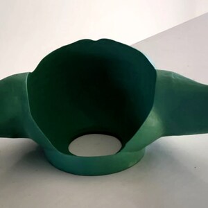 May include: Green felt Yoda mask with large ears. The mask is open at the front and has a hole in the bottom for the wearer's neck.