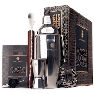 May include: A silver cocktail shaker set with a black and gold box. The set includes a shaker, a jigger, a bar spoon, a strainer, and a muddler. The box has the text "Mayfair Cocktail Shaker Set" on it.