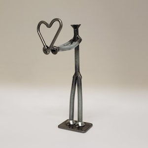 Welded nuts and bolts style figure holding heart