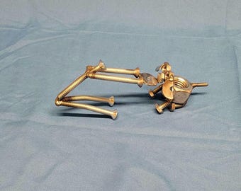 Welded metal nuts and bolts dog playing tug of war with frisbee