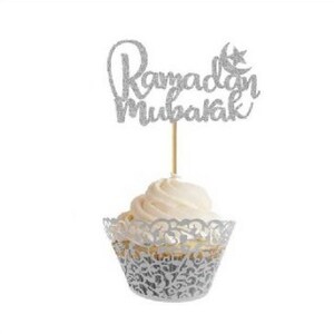May include: Silver glitter cupcake topper with the text "Ramadan Mubarak" and a crescent moon and star.