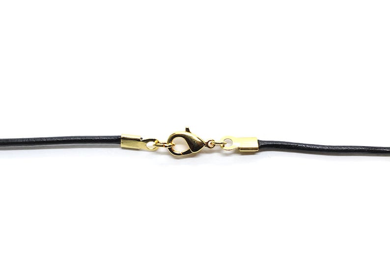 May include: A black leather cord necklace with a gold-toned lobster clasp.