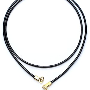 May include: A black leather cord necklace with a gold clasp. The cord is approximately 20 inches long.