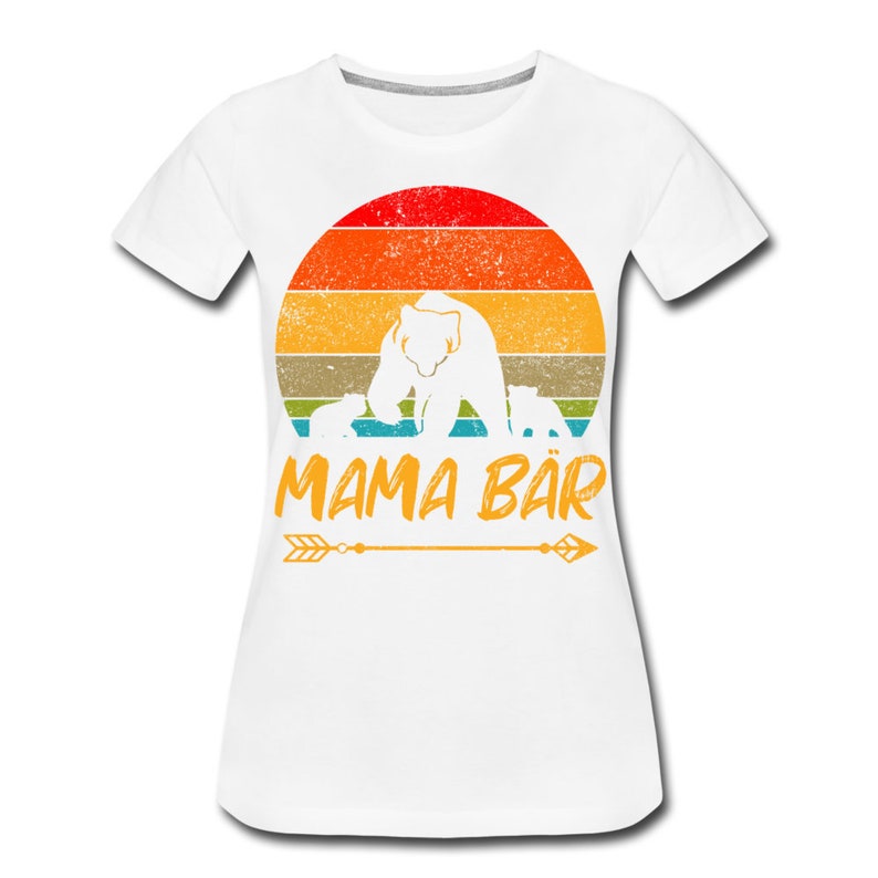 May include: White t-shirt featuring a vintage-style graphic of a mama bear and her cubs in front of a sunset. The text "MAMA B&Auml;R" is below the graphic.