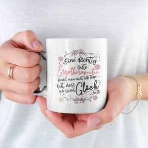 May include: White ceramic mug with a floral design and the text "Eine richtig gute Ergotherapeutin findet man nicht alle Tage - Gut, dass ich sowas Gl&uuml;ck hatte."