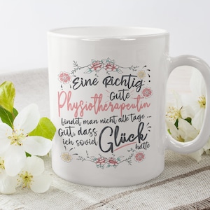 Könnte beinhalten: Weiße Keramiktasse mit Blumenmuster und dem Text "Eine Richtig Gute Physiotherapeutin bindet man nicht alle tage... Gut, dass ich soviel Glück hatte".