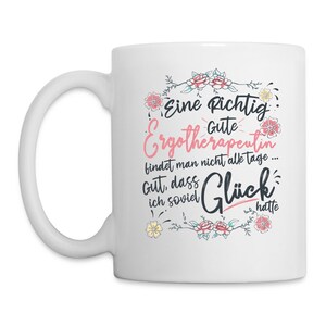 May include: White ceramic coffee mug with a pink and black design. The mug features a floral border and the text "Eine Richtig Gute Ergotherapeutin findet man nicht alle tage... Gut, dass ich soviel Gl&uuml;ck hatte".