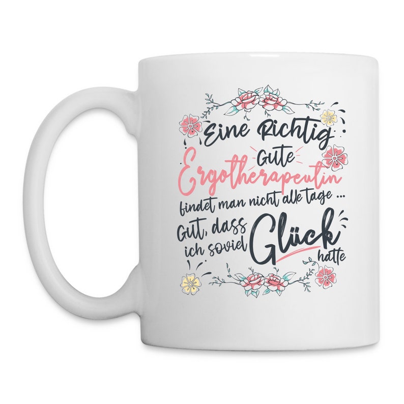 May include: White ceramic coffee mug with a pink and black design. The mug features a floral border and the text "Eine Richtig Gute Ergotherapeutin findet man nicht alle tage... Gut, dass ich soviel Gl&uuml;ck hatte".