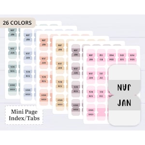 May include: A set of adhesive mini page index tabs in 26 colours, arranged on multiple sheets. Each tab features black text for months like JAN, JUN, NOV, and the word DAILY. The tabs have rounded corners and are organised in vertical columns.