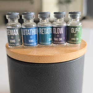 Peut inclure: Cinq petits flacons en verre transparent avec des bouchons en caoutchouc gris, chacun portant une étiquette colorée avec du texte blanc. Les étiquettes indiquent SEMAX, GLUTATHIO, RETATR, GLOW et GLP-T, avec des dosages 10MG, 30MG et 60MG/3ML.