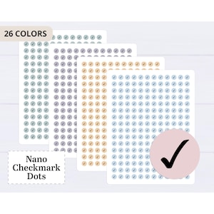 Puede incluir: Cuatro hojas de puntos de verificación nano en varios colores, incluyendo azul, morado y beige. Cada hoja está llena de pequeñas pegatinas circulares, cada una con una marca de verificación. El texto "26 COLORES" está en la parte superior izquierda y "Nano Checkmark Dots" en la parte inferior izquierda.