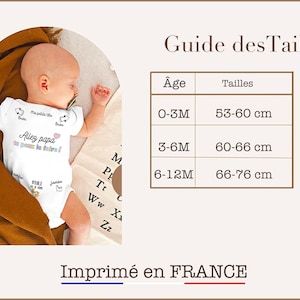 May include: A white baby onesie with the text "Allez papa on peut le faire!" in French. The onesie also has a small heart and a drawing of a baby foot. A size chart is included with the text "Guide des Tailles" and the sizes in centimeters for ages 0-3 months, 3-6 months, and 6-12 months. The text "Imprim&eacute; en FRANCE" is at the bottom of the image.