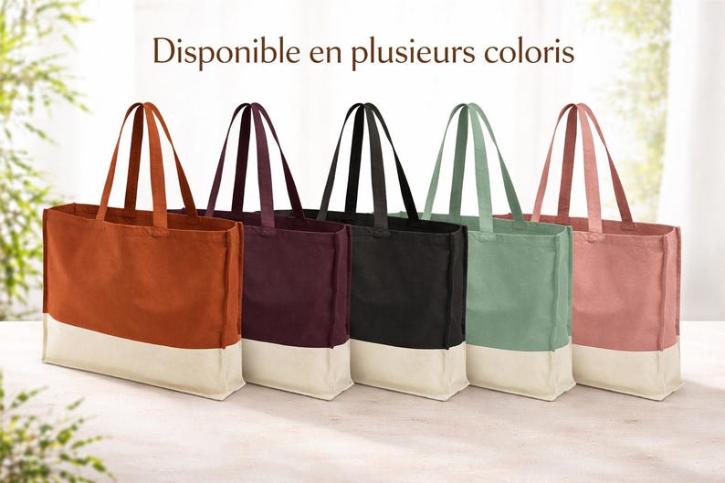May include: Five canvas tote bags in shades of rust, burgundy, black, sage green, and dusty rose. Each bag features a contrasting off-white base and matching handles. The French text "Disponible en plusieurs coloris" is visible at the top.