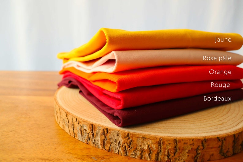 May include: A stack of five fabric swatches in various shades of orange, red, and yellow. The swatches are labeled from top to bottom: Jaune, Rose p&acirc;le, Orange, Rouge, Bordeaux.