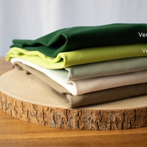 May include: Stack of five fabric swatches in different shades of green, sage, white, and khaki. The swatches are labeled "Vert bouteille", "Vert Pomme", "Sage", "Blanc", and "Kaki".