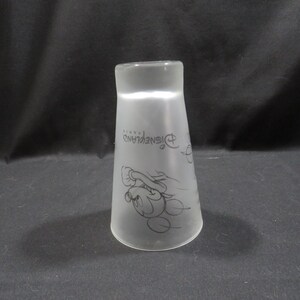 Op de afbeelding: Matglazen Disneyland Parijs souvenirbeker. De beker heeft een zwarte omtrek van Mickey Mouse en het Disneyland Parijs-logo. De beker heeft een uitlopende vorm en is enigszins doorschijnend.