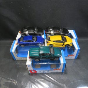 May include: A collection of die-cast model cars in various colors, including black, blue, yellow, and green. The toy cars are displayed on their original boxes, with the brand name "Burago" visible. The scale of the models is 1/43.