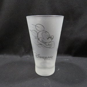 Op de afbeelding: Matte glazen tumbler met een schets van Mickey Mouse in beweging. De woorden "Disneyland Paris" staan op het glas. De tumbler is cilindrisch met een licht uitlopende bovenkant.