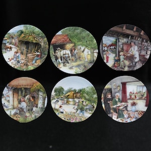 Può includere: Set di sei piatti decorativi con scene rurali dettagliate e colorate. Ogni piatto presenta un'immagine pastorale diversa, con persone, animali ed edifici. I piatti rotondi sembrano essere in porcellana.