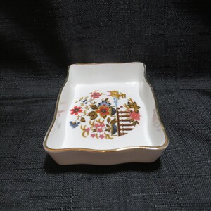 May include: A white ceramic trinket dish with a gold rim and a floral design in shades of red, blue, pink, and green.