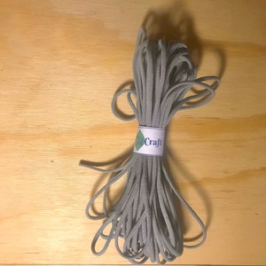 May include: A gray elastic cord wound into a coil, with a white label that reads "igCraft".
