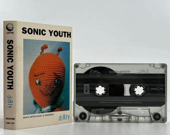 Op de afbeelding: Een cassettebandje van het album "Dirty" van Sonic Youth. De cassetteband is in een doorzichtige plastic cassette met een zwart label. Het label heeft de naam van de band en de albumtitel in wit gedrukt. De cassetteband is een fysiek muziekformaat.