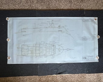 May include: A blueprint drawing of a boat with detailed plans for the hull, deck, and interior. The drawing is on a blue background with black lines.