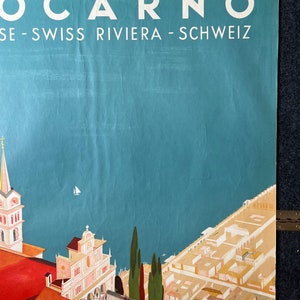 May include: A vintage travel poster advertising the Swiss Riviera town of Locarno. The poster features a colorful illustration of the town with a church, buildings, and trees. The text "Locarno" is in large white letters at the top of the poster, and the text "SE - SWISS RIVIERA - SCHWEIZ" is in smaller white letters below it.