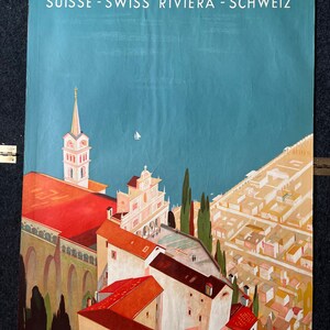May include: A vintage travel poster advertising the Swiss Riviera town of Locarno. The poster features a colorful illustration of the town's architecture, including a church with a tall steeple, and a view of the lake. The text "Locarno" is written in large, bold letters at the top of the poster, and the text "Suisse - Swiss Riviera - Schweiz" is written below it.