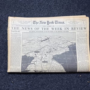 May include: A vintage copy of The New York Times newspaper, featuring the headline "THE NEWS OF THE WEEK IN REVIEW." The front page includes a map of Korea and text about World War III. The paper is aged with a yellowed appearance.