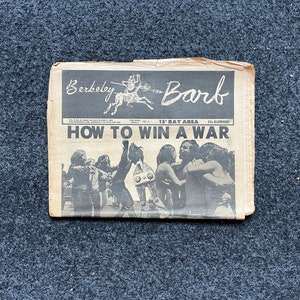 Op de afbeelding: Een zwart-witte krant met de kop "Hoe een oorlog te winnen" en de titel "Berkeley Barb" bovenaan. De krant bevat een foto van een groep mensen die vieren.