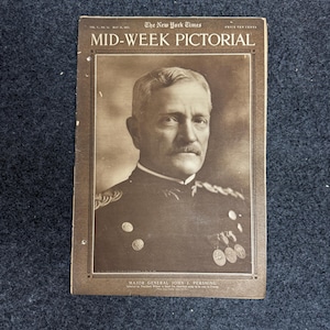 May include: A sepia-toned vintage magazine titled The New York Times Mid-Week Pictorial from May 31, 1917. The cover features a portrait of Major General John J. Pershing in a military uniform with medals, set against a dark border and text.