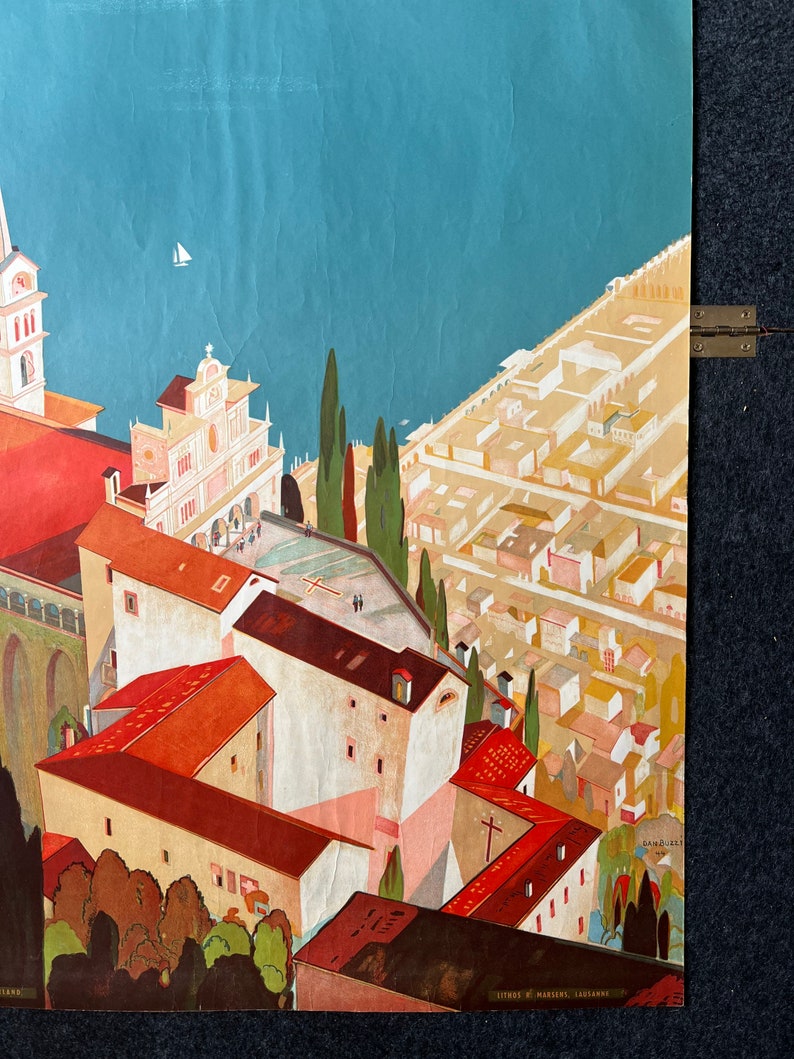 May include: A vintage travel poster featuring a colorful illustration of a city with red-roofed buildings, a church, and a body of water. The poster has the text "LITHO. DE MARIGNIER, LAUSANNE" at the bottom.