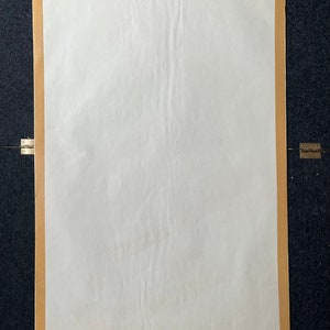 May include: A blank white poster with a brown paper border. The poster is slightly wrinkled.