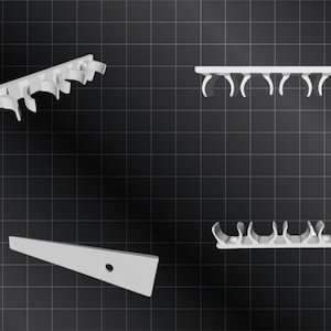 Könnte beinhalten: Vier weiße Kunststoff-Rohrhalter, zwei sind gerade und zwei sind gebogen. Die Halter sind so konzipiert, dass sie Rohre oder Kabel an Ort und Stelle halten.
