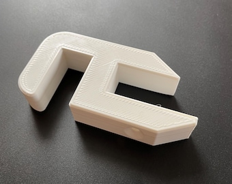 May include: White plastic 3D printed object shaped like a C with a hole in the middle.